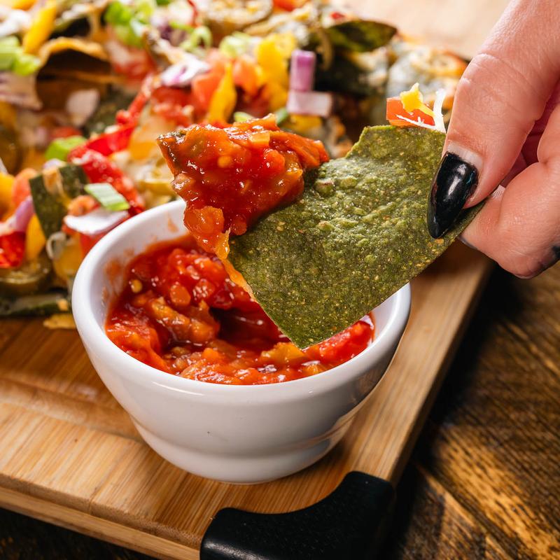 Nacho chip being dipped in salsa at The Royal