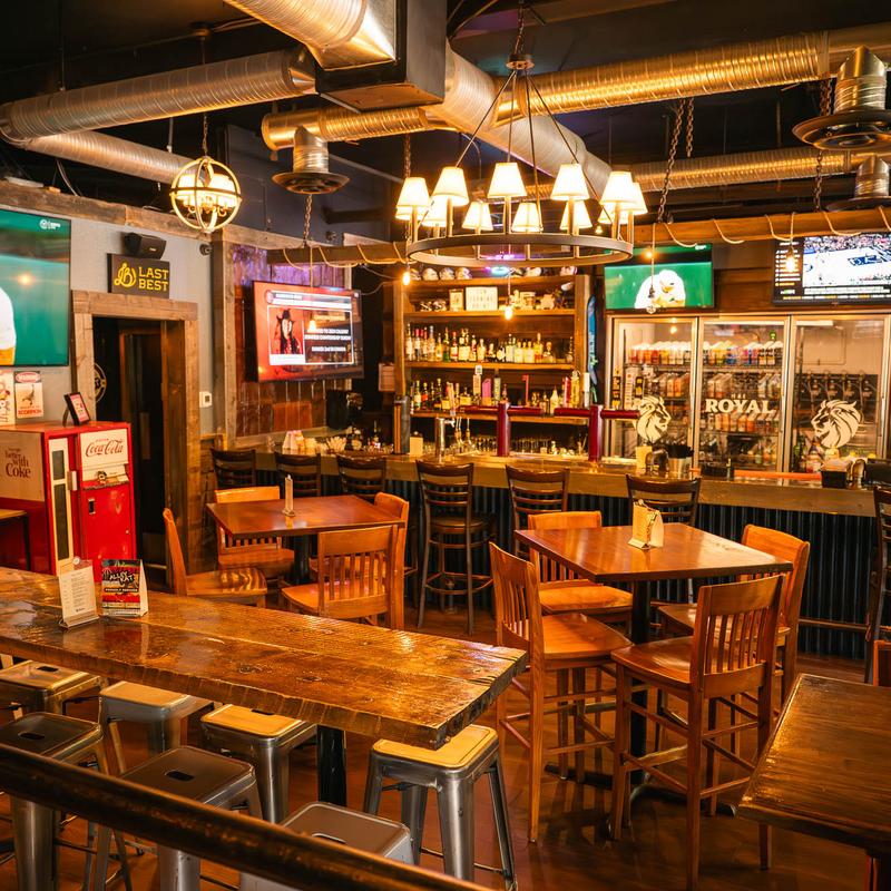 The Royal bar — dark ceiling, brass chandelier, 12 screens